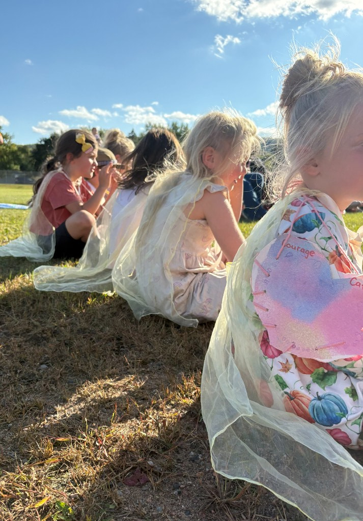 Children wearing yellow capes with handmade courage hearts at the Festival of Courage