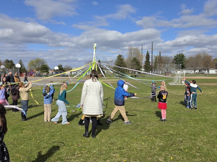 The whole school gathered in the field, winding ribbons around the maypole together
